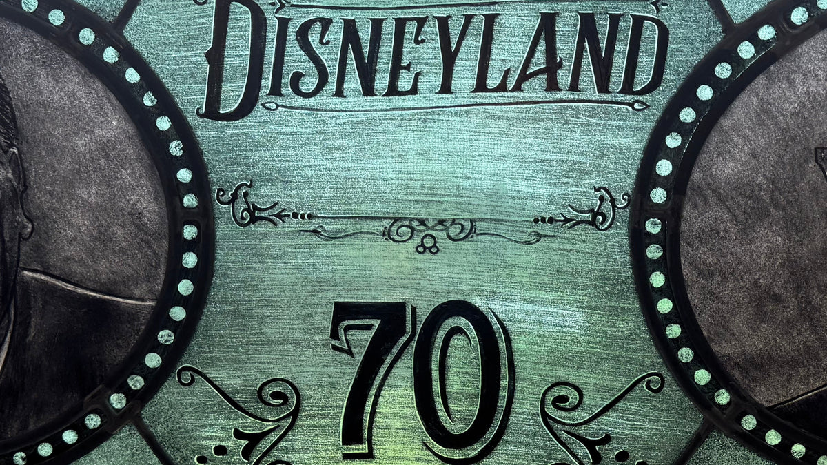 Stained glass window with portraits of two Walt and Roy Disney and 'Disneyland 70' text.