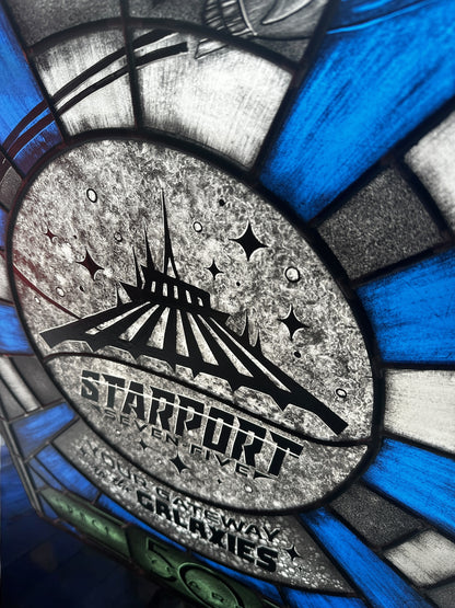 Stylized sign with 'Starport Seven Five' design,  stained glass. Blue and white launch tunnel background. '50 years Space Mountain' text. rocket with astronaut blasting off. 'Your Gateway to the Galaxies' text.