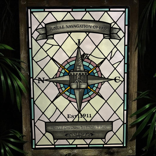 Stained glass panel with compass design and text, framed by green foliage. Disney Jungle Navigation Company