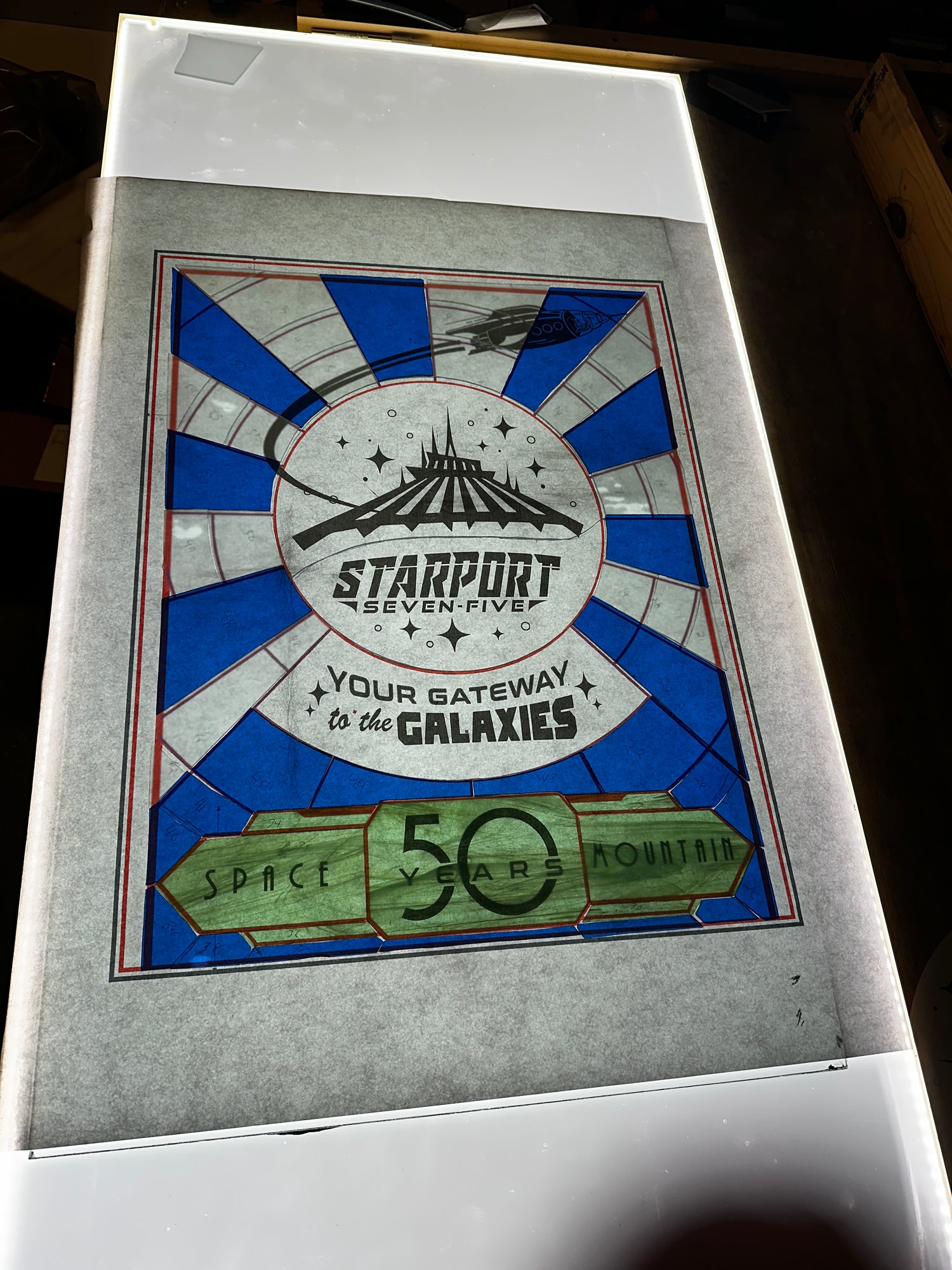 Stained glass panel with 'Starport seven  -five' design on a white surface, space mountain in the magic kingdom in Disney world