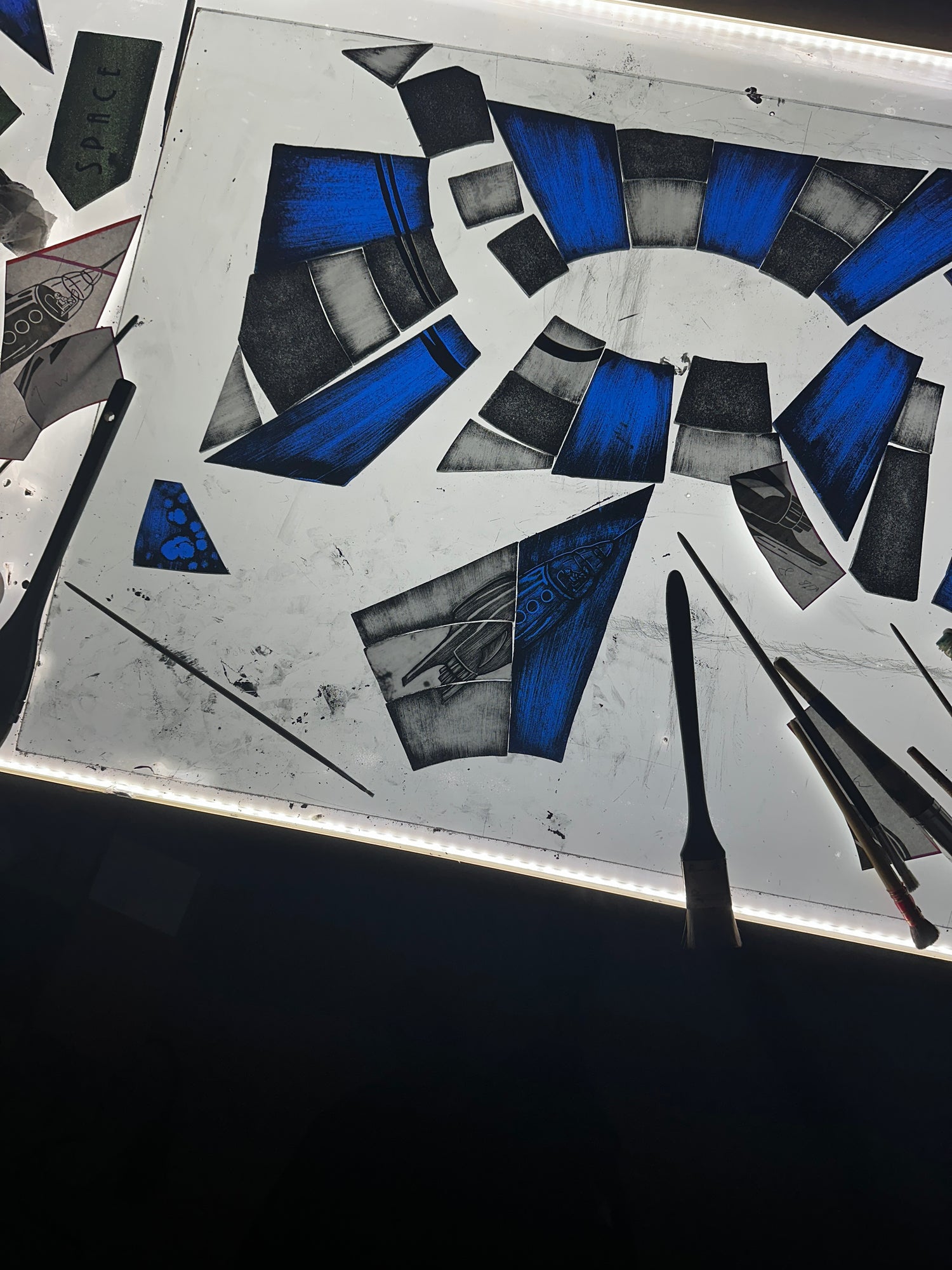 painted stained glass pieces with rocket ship and space man. Part of 'spaceport seven - five' branding from space mountain in  the magic kingdom at Disney world