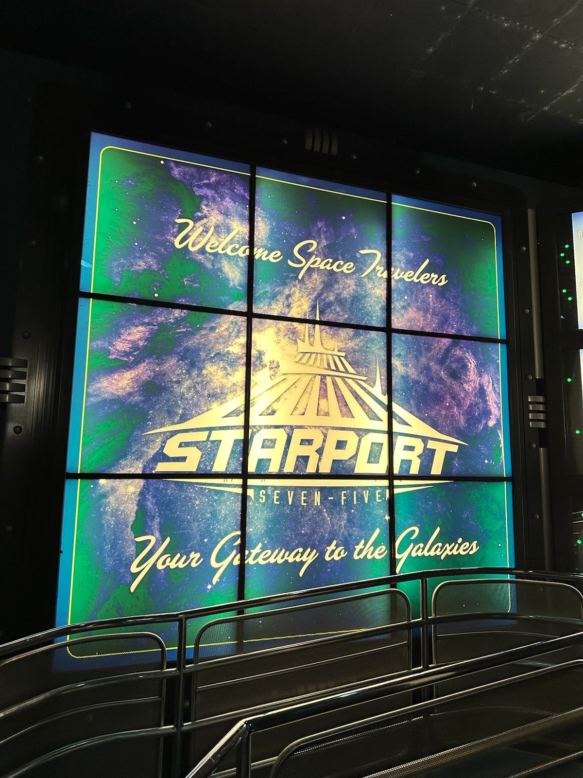 Large digital display with 'Starport seven - five' branding and space-themed graphics, space mountain in disney world